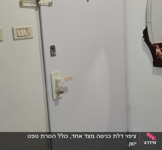 דלת לבנה עם ידית ומנעול כסופים